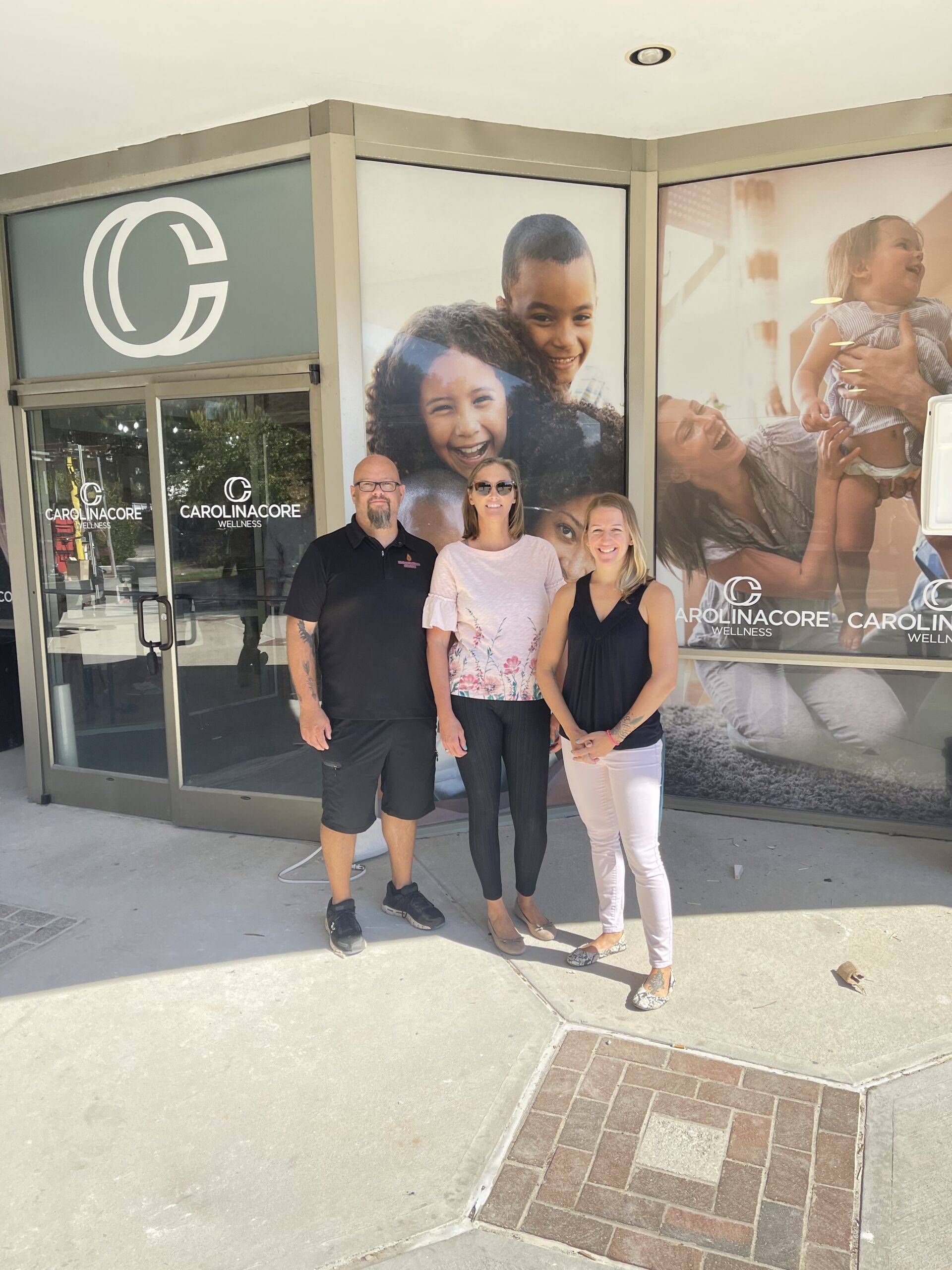 Three people standing in front of a store advertising childcare services in Highpoint.